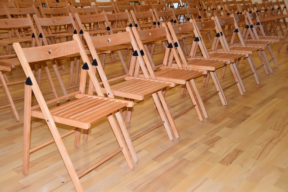 Zdjęcie krzeseł składanych, które wykonane są z jasnego drewna.