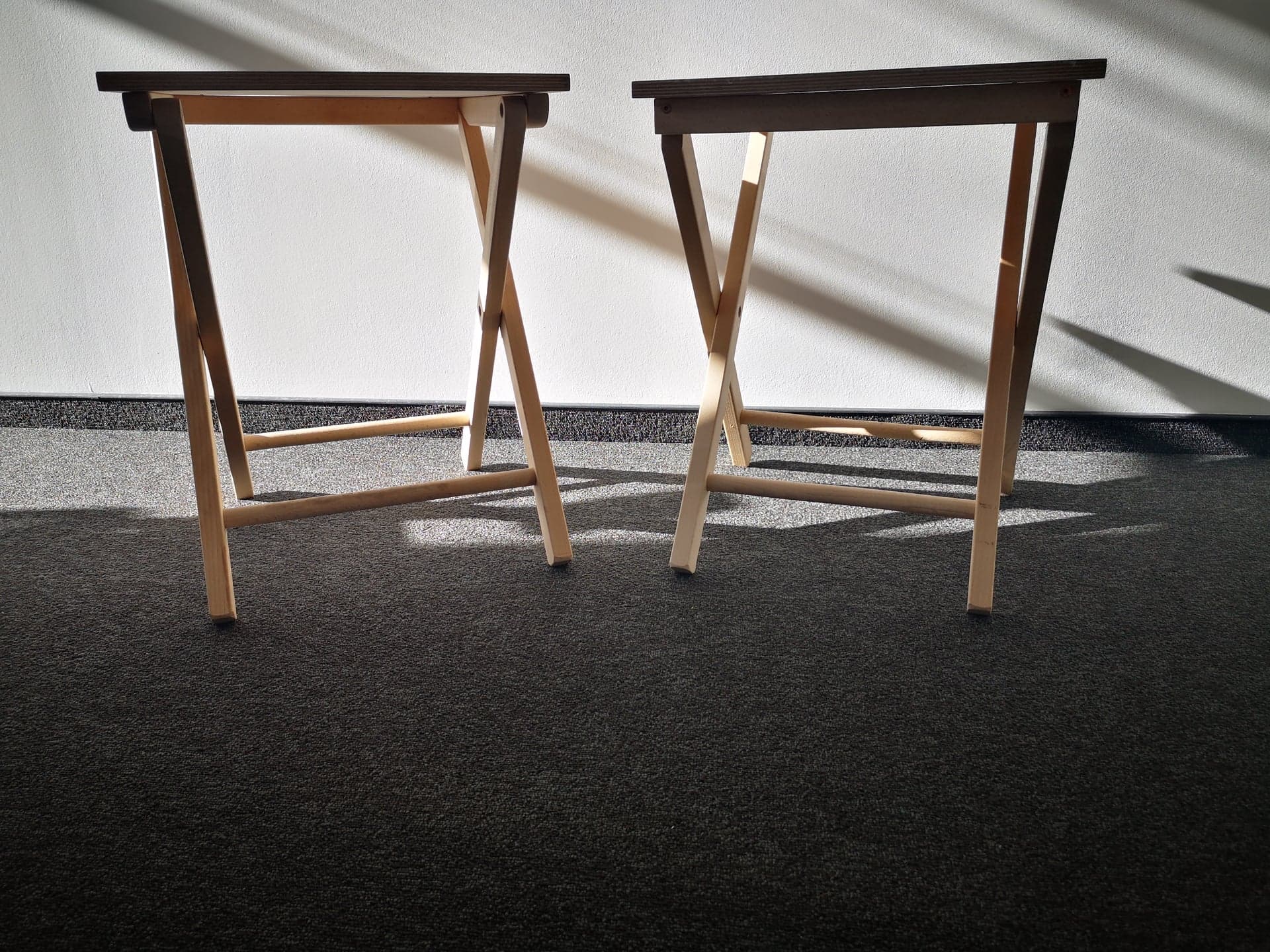 Dwa rozłożone, drewniane stoliki.