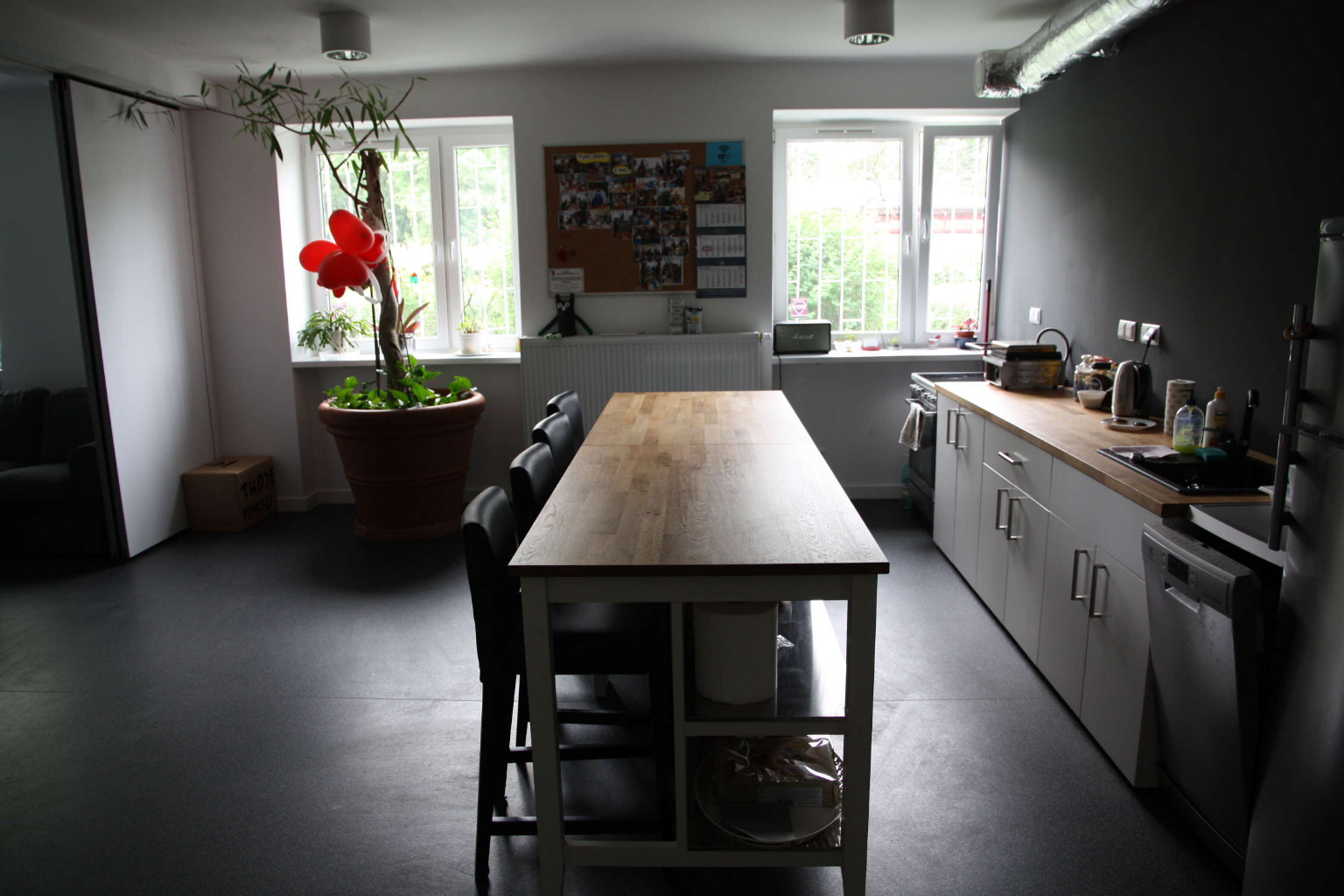 Zdjęcie kuchni z szafkami, miejscami do siedzenia i stołami.